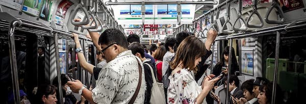 People using phones on the train